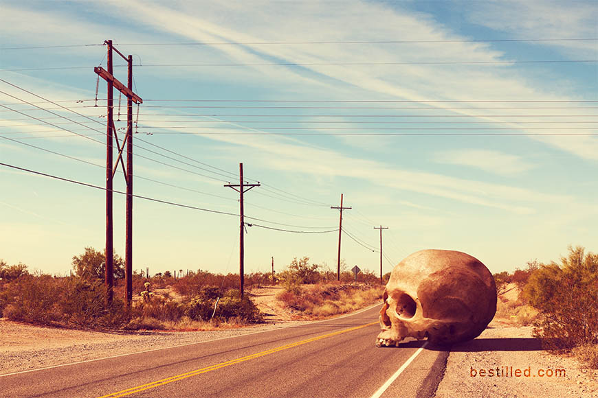 Giant skull on desert highway in Arizona, surreal artwork by Joseph Westrupp.