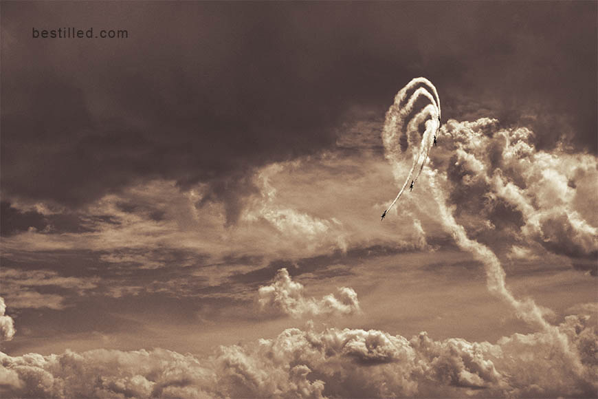 Southend Air Show stunt planes trailing smoke in clouds, art photo by Joseph Westrupp.