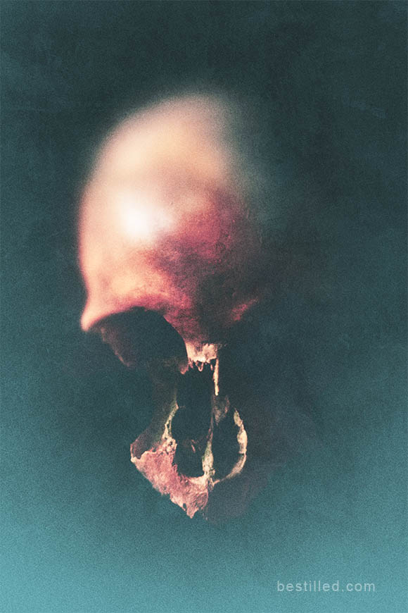 Eroded skull with parts of face missing, art photograph in blue and orange by Joseph Westrupp.